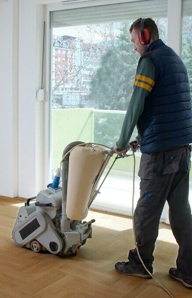 Belt sander in use on herringbone parquet